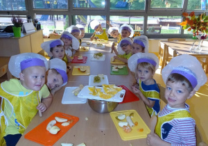 04 Dzieci siedzą przy stolikach, na deseczkach mają owoce